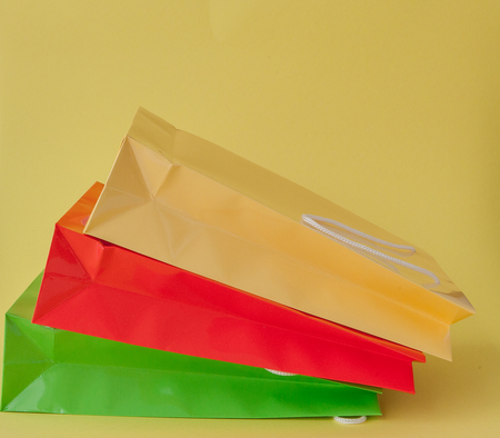 Colorful shopping bagss isolated on yellow background.の写真素材