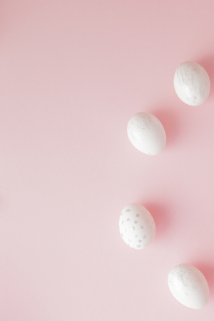 White Easter eggs on pink background with copy space. Top view shot of arrangement decoration Happy Easter holiday background concept. Design pastel tone in minimal flat lay.の写真素材
