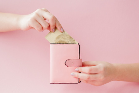 wallet and credit card in woman's hand on pink background.の写真素材