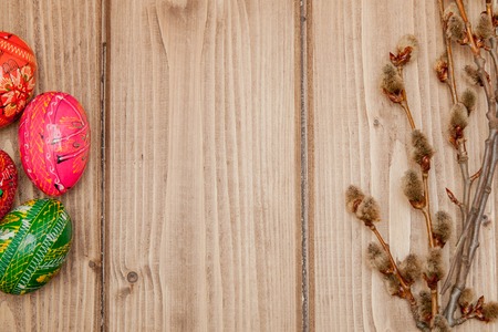 Still life with Pysanka, decorated Easter eggs, dry willow branches on black wooden background, top view, copy space.の写真素材