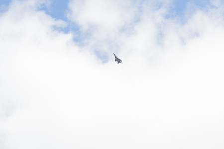 Military fighter in the blue sky with white clouds.の写真素材