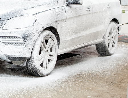 Car wash with foam in car wash station. Carwash. Washing machine at the station. Car washing concept. Car in foam.の写真素材