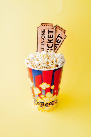 Movie tickets, film strips and popcorn on blue background. Copy space for text.