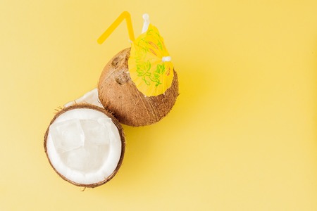 Fresh Coconut cocktail with a straws on yellow background, copy space.の写真素材