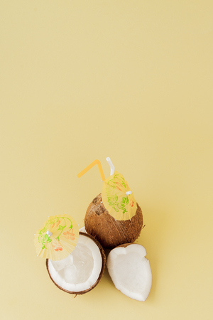 Fresh Coconut cocktail with a straws on yellow background, copy space.の写真素材