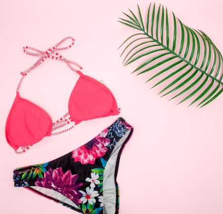 Hat, swimsuit, sunglasses on pink background. Top view, flat lay, space for textの写真素材