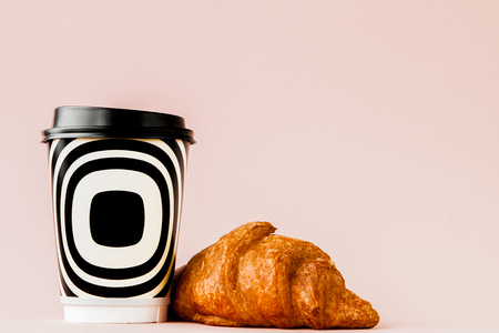 Paper cup of coffee and croissants on a pink background, Copy spaceの写真素材