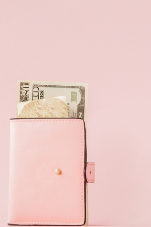 Dollars and pink wallet with credit card on pink background.の写真素材