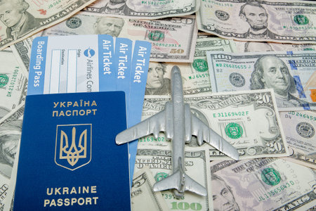 Airplane, passport and airline tickets against the background of dollars.
