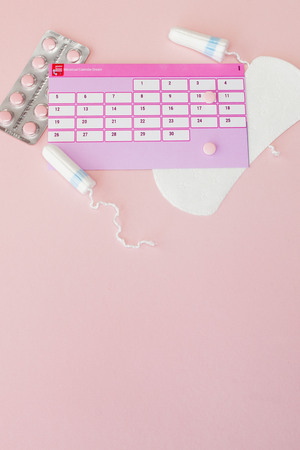 Tampon, feminine, sanitary pads for critical days, feminine calendar, pain pills during menstruation on a pink background. Tracking the menstrual cycle and ovulation.の写真素材