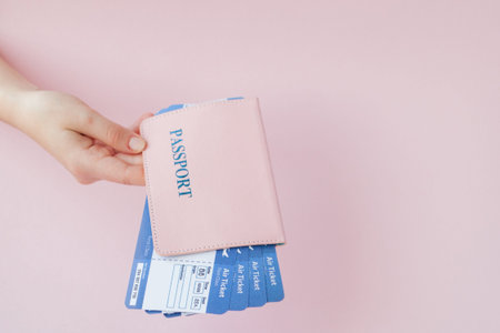 Close up tourist female horizontal hold in hand tickets for plane with orange passport, boarding...