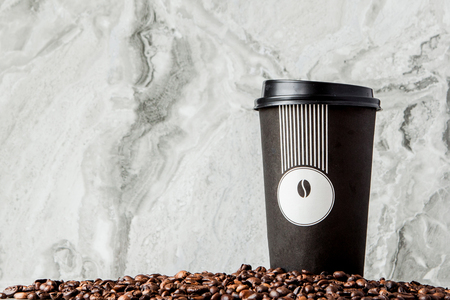 Black coffee in cup and coffee beans on marble background. Top view, space for text.の写真素材