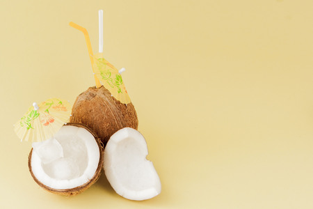 Fresh Coconut cocktail with a straws on yellow background, copy space.の写真素材