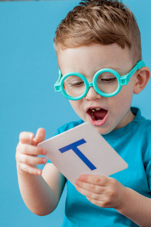 Cute little boy with letter on background. Child learn letters. Alphabet.の写真素材