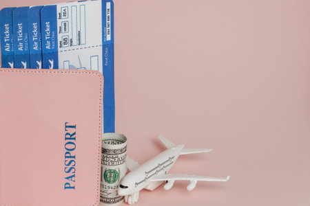 Passport, dollars, plane and air ticket on a pink background. Travel concept, copy space.の写真素材