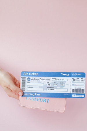 Close up tourist female horizontal hold in hand tickets for plane with orange passport, boarding...