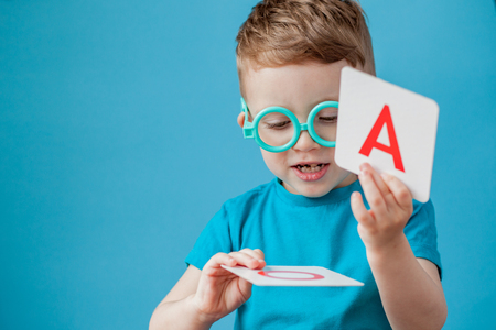 Cute little boy with letter on background. Child learn letters. Alphabet.の写真素材
