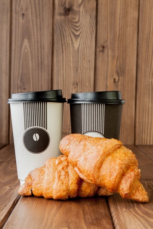 Paper coffee cup and croissants on wooden background, Copy space.の写真素材