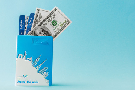Passport, dollars and air ticket on a blue background. Travel concept, copy space.の写真素材