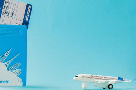 Passport, airplane and air ticket on a blue background. Travel concept, copy space.