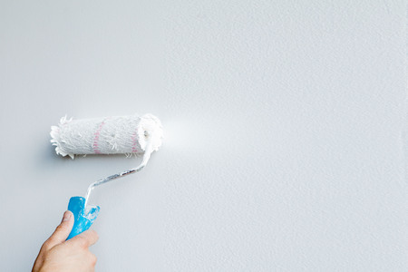 Woman hand holding a paint roller isolated on a white background.の写真素材
