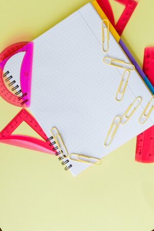 Back to school concept with space for text. Top view. Copy space. School office supplies.Creative desk with colourful stationery. Colored paper clip.School supplies on yellow background.Office deskの写真素材