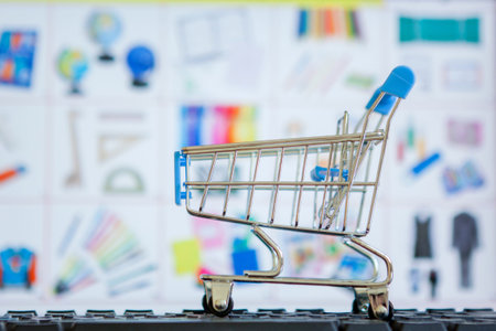 Shopping cart full of school tools on the keyboard, online shopping concept.