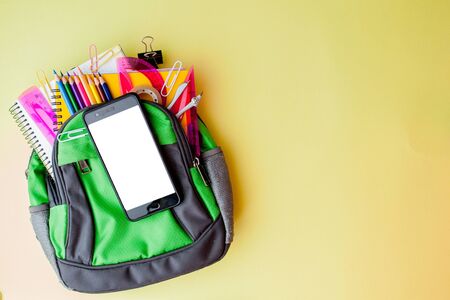 Flat lay composition with backpack and school stationery on yellow background.の写真素材