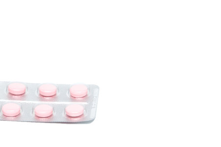 Pink tablet pills in blister , isolated on white background.の写真素材