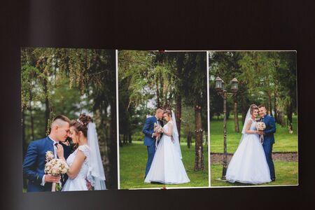 Kyiv, Ukraine- May 15, 2019 Pages of wedding photobook or wedding album on black background.のeditorial素材