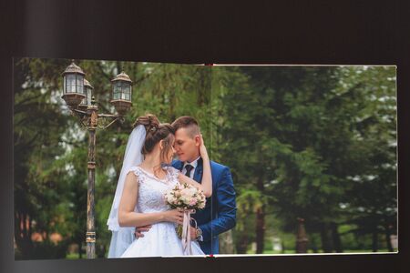 Kyiv, Ukraine- May 15, 2019 Pages of wedding photobook or wedding album on black background.のeditorial素材