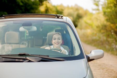 Portrait shot through windshield of pretty woman in car.の写真素材