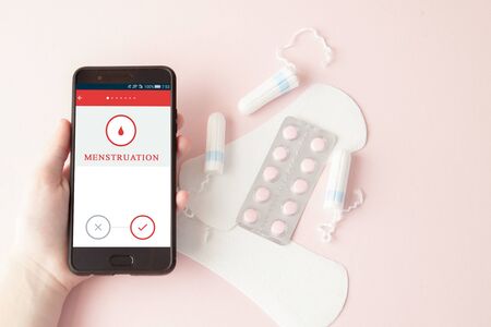 Tampon, feminine, sanitary pads for critical days, feminine calendar, pain pills during menstruation on a pink background. Tracking the menstrual cycle and ovulation.の写真素材