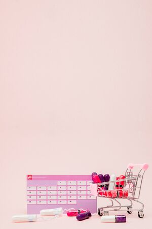 Tampon, feminine, sanitary pads for critical days, feminine calendar, pain pills during menstruation on a pink background. Tracking the menstrual cycle and ovulation.の写真素材