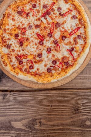 Pizza Restaurant Menu - Delicious Spicy Pizza with Sausages and Chili Pepper. Pizza on Rustic Wooden Table with Ingredients.の写真素材