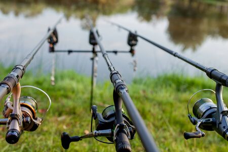 Closeup of a reel fishing rod on a prop and water background.の写真素材