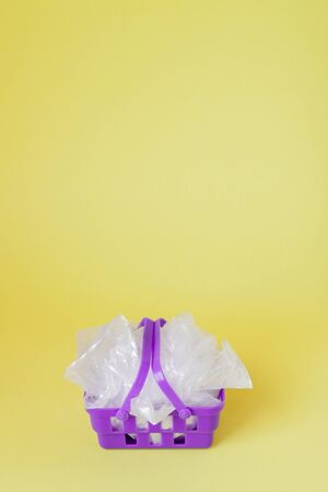polythene bags in shopping basket on yellow background.の写真素材