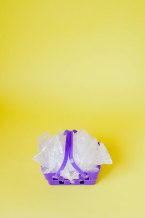 polythene bags in shopping basket on yellow background.の写真素材