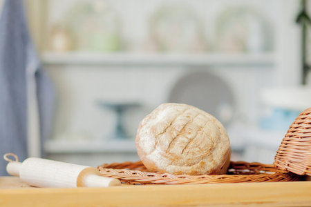 Breads near a wicker basket on a table in a rustic kitchen. Composition in kitchen at the photo...