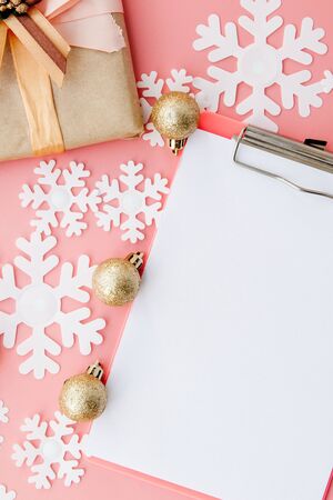 Christmas gifts, Christmas ornaments and an open blank notebook on pink background. Flat lay. Top viewの写真素材