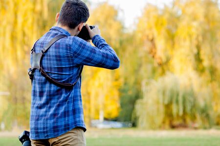 Professional photographer in action with two cameras on a shoulder straps.の写真素材