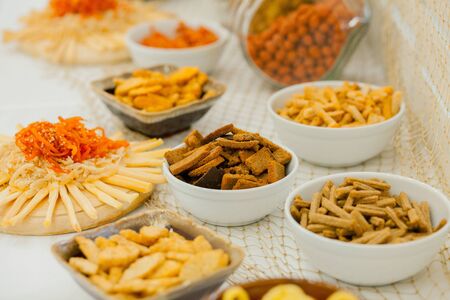 A lots of salty snacks on a table, many cheese and crackers on the table with snacks.の写真素材