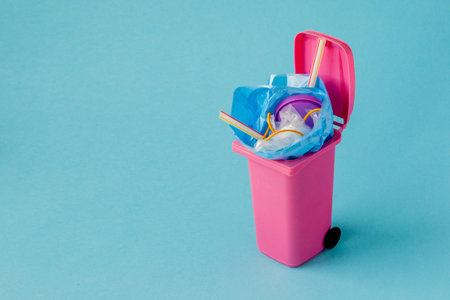 Studio shot of a pink big trash on blue background.