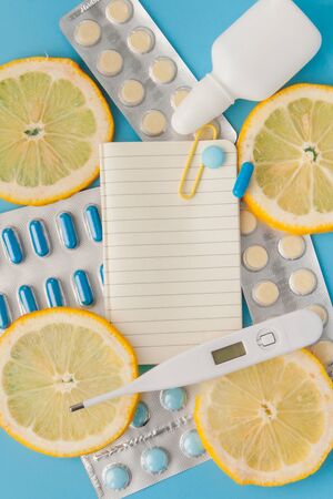 Medications, pills, thermometer, traditional medicine for treating colds, flu, heat on a blue background. Maintenance of immunity. Seasonal diseases. Top view. Medicine flat lay.の写真素材