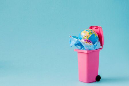 Earth globe lies in the trash. The globe lies in a heap of plastic. Plastic pollution of nature.の写真素材