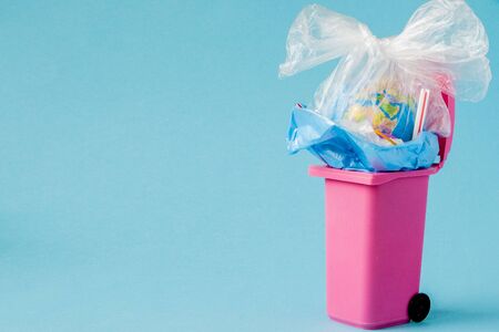 Earth globe lies in the trash. The globe lies in a heap of plastic. Plastic pollution of nature.の写真素材