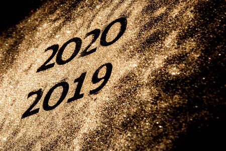 Beautiful sparkling Golden Numbers of 2019 to 2020 on black background for design, happy new year concept.の写真素材