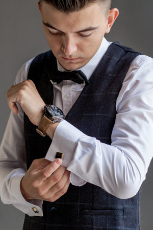 Man gets ready for work by buttoning up his business shirt. Groom's morning preparation before...
