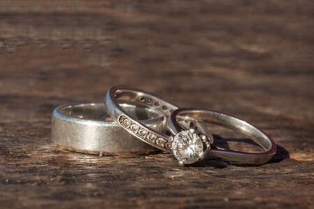Wedding and Engagement rings on woden background.の写真素材
