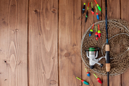Fishing tackle - fishing rod fishing float and lures on beautiful blue wooden background, copy...